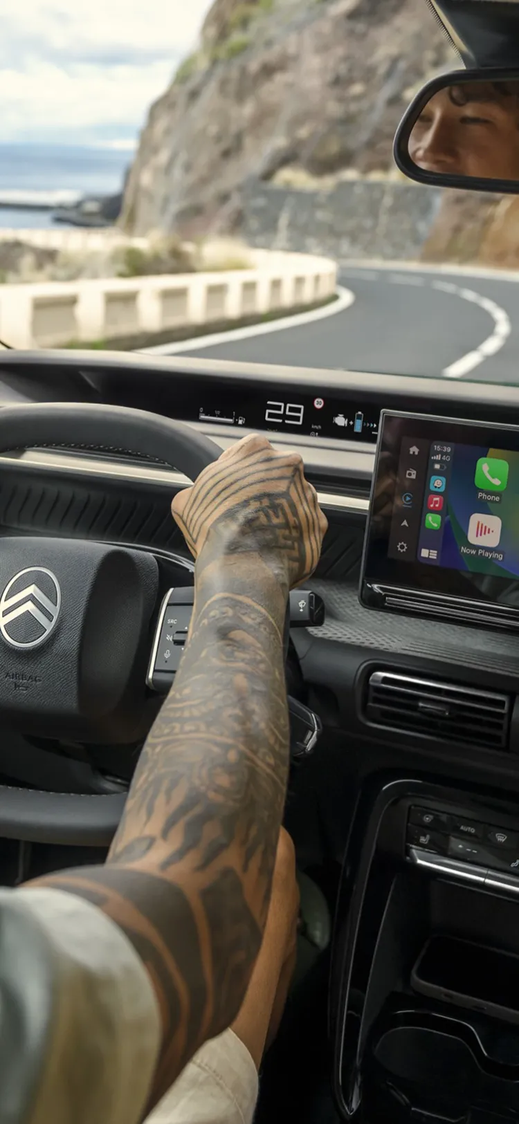 Fahreransicht des Citroën C3 Aircross SUV zeigt großen Infotainment-Bildschirm für intuitive, connected and erschwingliches Alltagsfahren on coastal roads.